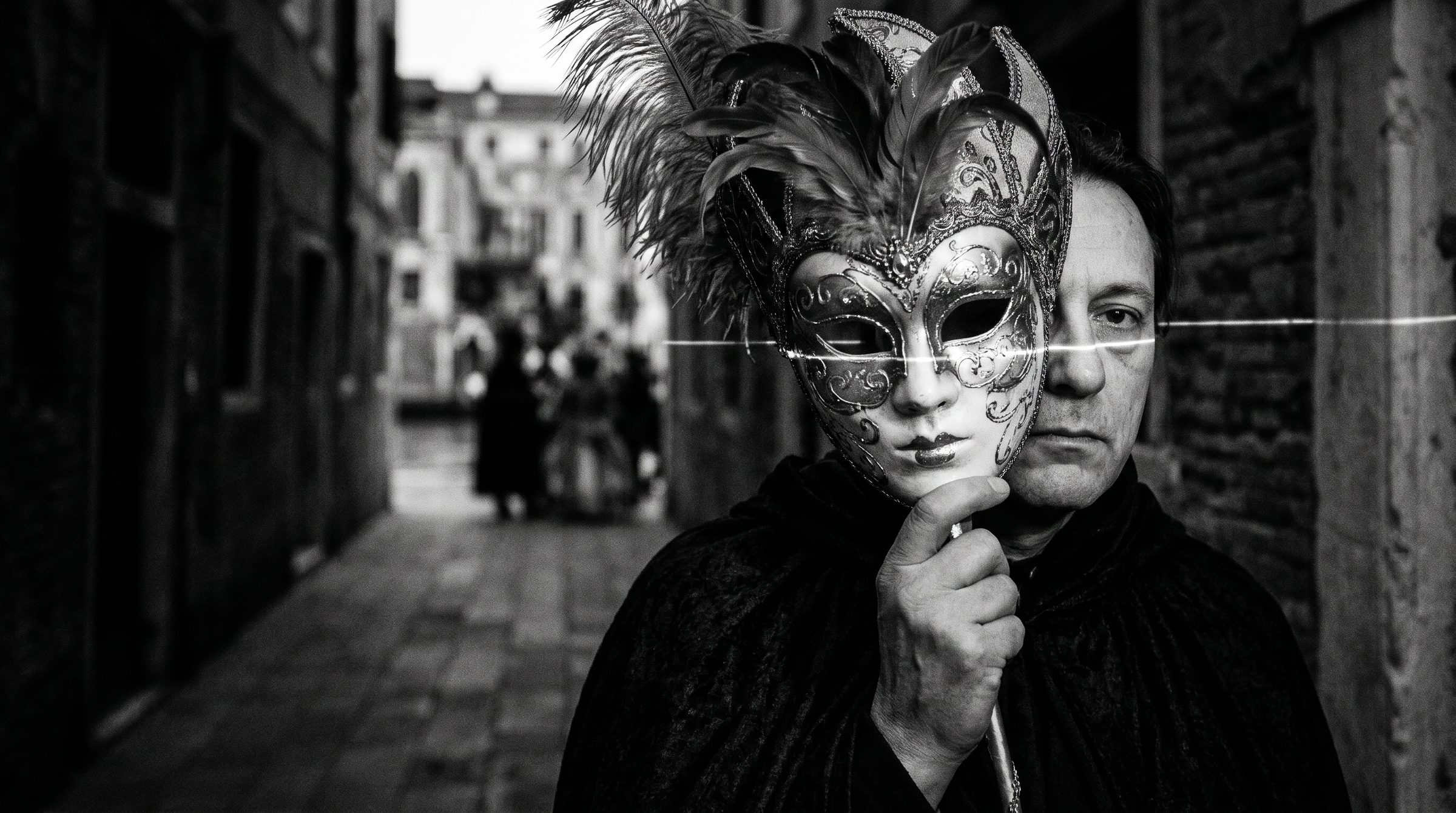 A man in a dark Venetian alley lowers an ornate carnival mask from his face: the brand performed versus the brand delivered.